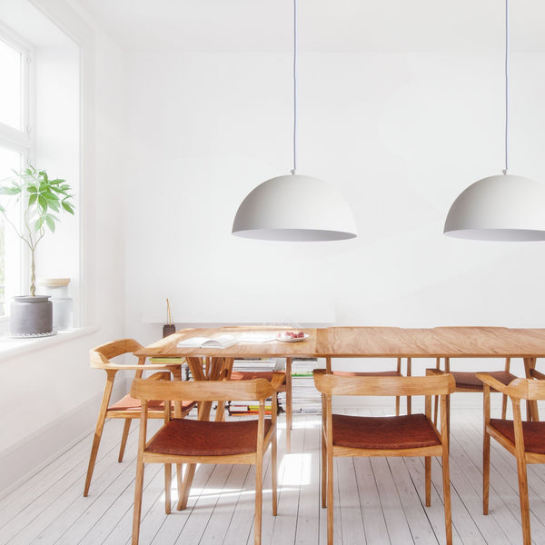 Chambre moderne avec lit blanc, draps gris, et fenêtres donnant sur l'extérieur | Entrepôt de la Réno
