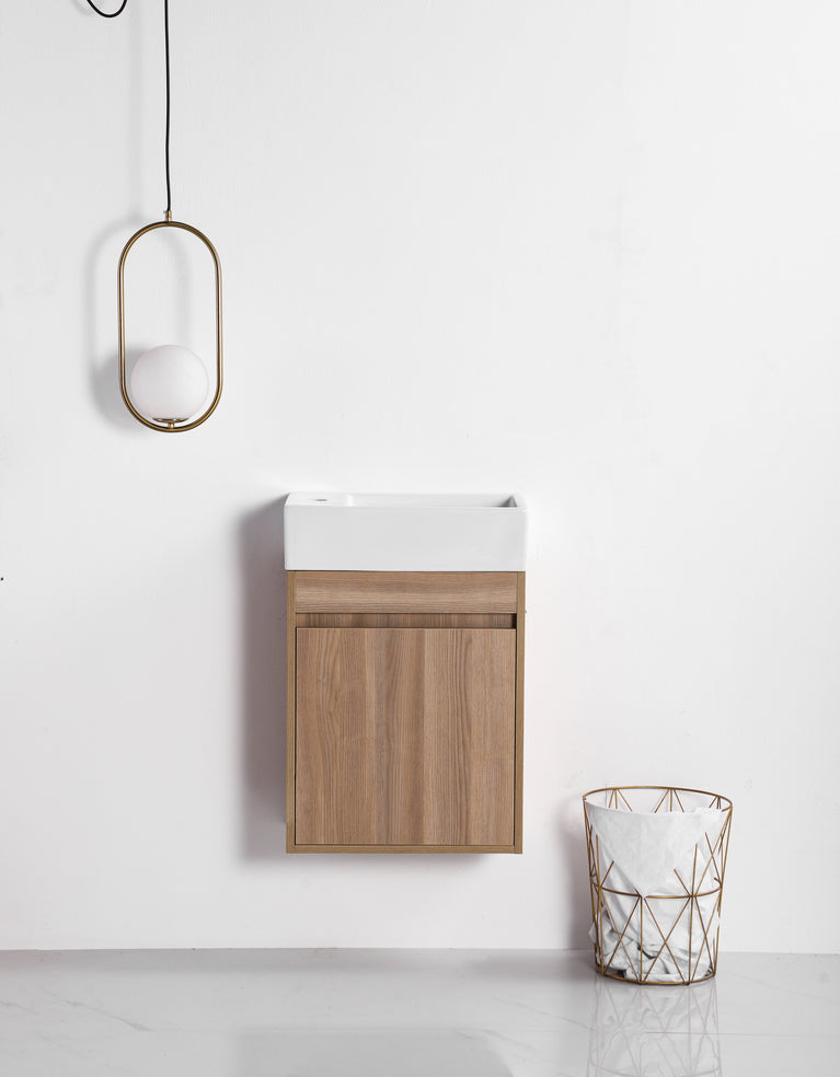 Meuble-lavabo compact en bois naturel de 18 pouces avec évier blanc intégré, suspendu au mur. Lampe pendante ovale et panier décoratif à côté, style scandinave minimaliste pour petite salle de bain.