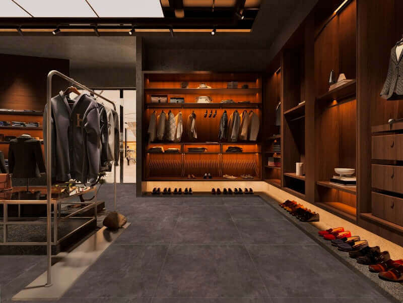 Dressing luxueux avec un plancher en céramique gris foncé, comprenant des étagères en bois chaleureux, des supports suspendus pour vêtements et des présentoirs à chaussures, le tout mis en valeur par un éclairage d’ambiance doux.