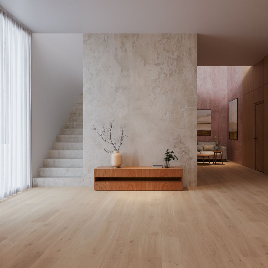 Intérieur moderne avec plancher en chêne blanc, murs texturés, escalier blanc, meuble en bois et plantes décoratives. Espace lumineux et minimaliste illustrant la beauté du plancher d'ingénierie. Nouveautés, En stock, Tous produits, Plancher d'ingénierie
