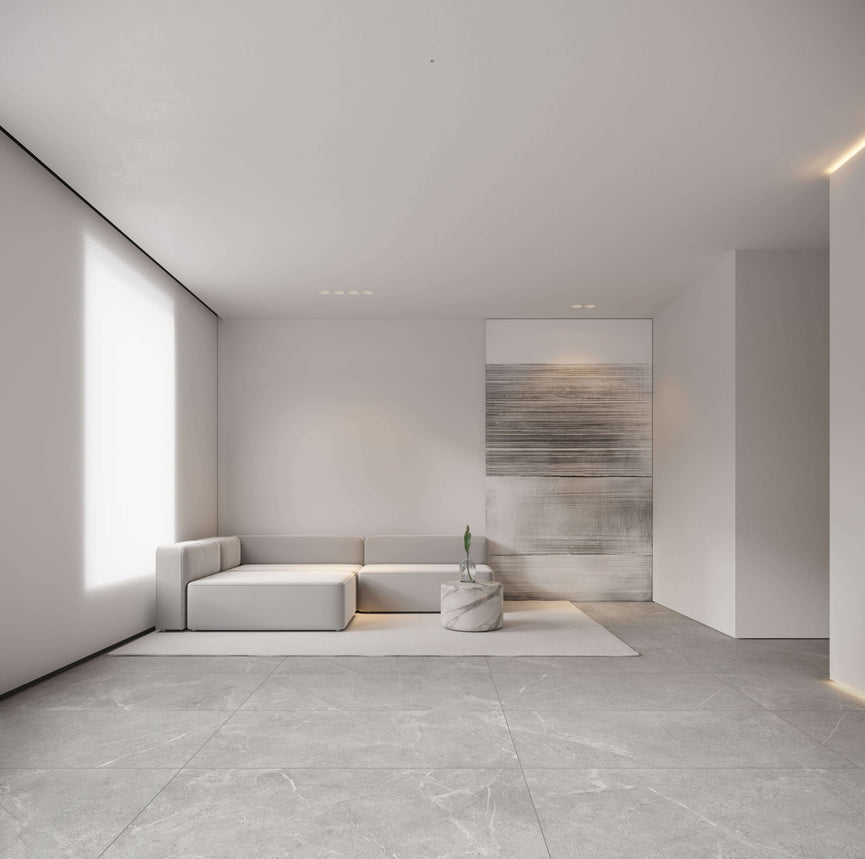 Salon minimaliste avec carrelage Céramique Great Stone Light Grey, canapé moderne et décoration épurée, illustrant l'élégance et la polyvalence du produit pour sols et murs dans un espace résidentiel contemporain