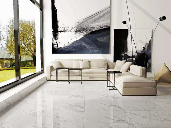 Salon moderne avec carrelage Céramique Calacatta Cielo White Polie, canapé blanc, grande fenêtre et œuvre d'art abstraite. Sol en céramique blanc brillant reflétant la lumière naturelle, créant une atmosphère lumineuse et spacieuse.