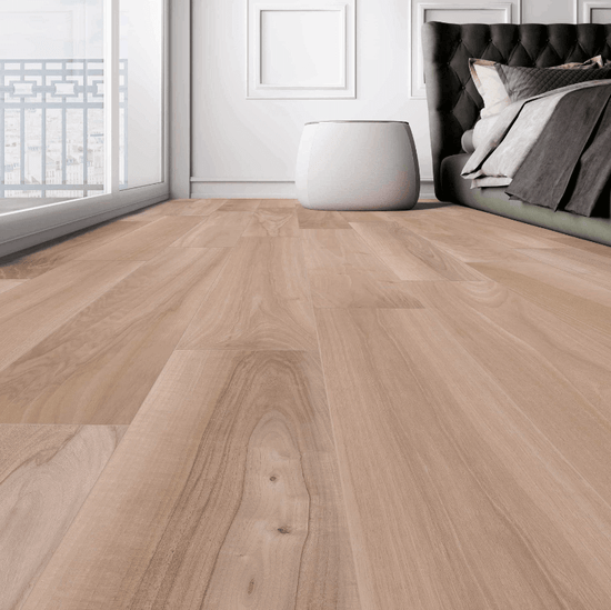 Plancher en céramique effet bois chêne Céramique Wood K Chêne dans une chambre moderne avec lit capitonné noir et table basse blanche, offrant une ambiance chaleureuse et élégante
